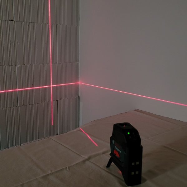 photo d'un niveau laser qui affiche le niveau sur deux murs